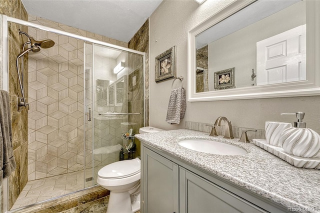 bathroom with walk in shower, vanity, and toilet