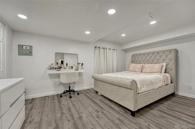 bedroom featuring electric panel and light hardwood / wood-style flooring