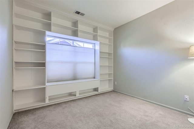 unfurnished living room featuring built in features and carpet flooring