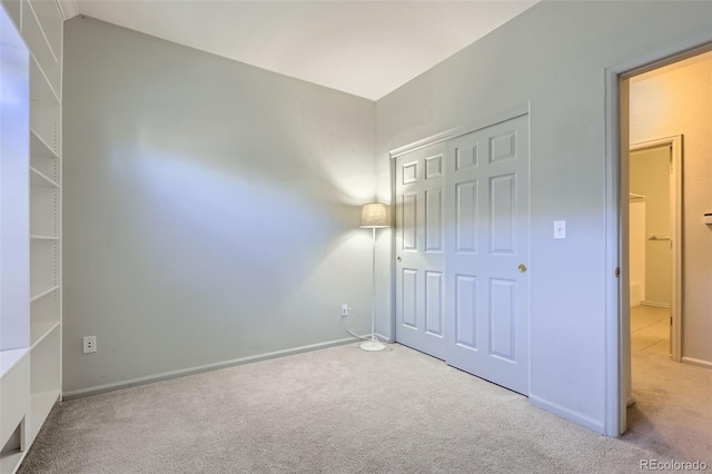 unfurnished bedroom featuring light colored carpet and a closet