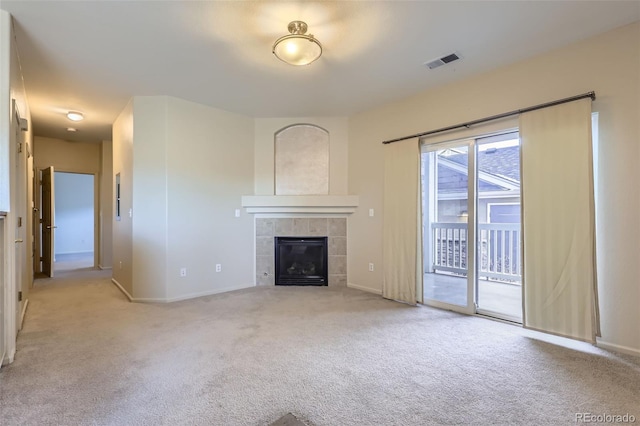 unfurnished living room with light colored carpet and a fireplace