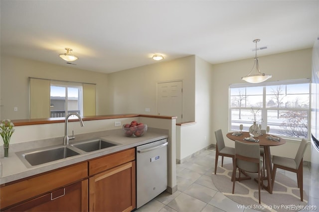 kitchen featuring light tile patterned floors, dishwasher, sink, and pendant lighting