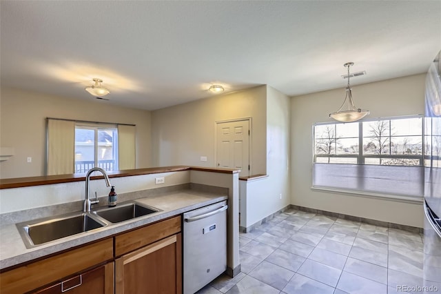 kitchen with sink, hanging light fixtures, light tile patterned floors, and dishwasher