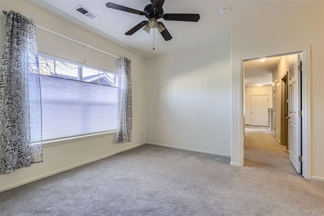 carpeted spare room featuring ceiling fan