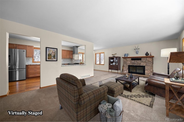 993 Fall River Rd, Idaho Springs, CO 80452 - living area featuring baseboards, carpet flooring, a stone fireplace, and visible vents