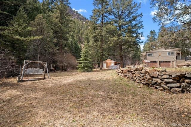 993 Fall River Rd, Idaho Springs, CO 80452 - view of yard with an attached garage and a view of trees