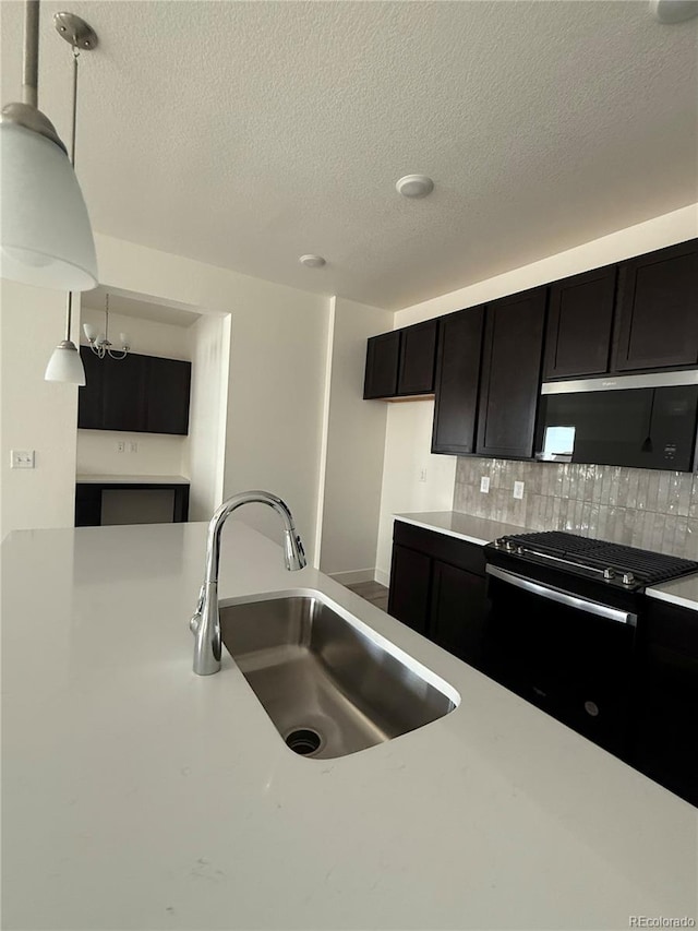 6113 Zebulon Pl, Timnath, CO 80547 - kitchen with a sink, light countertops, black range with gas stovetop, tasteful backsplash, and a textured ceiling