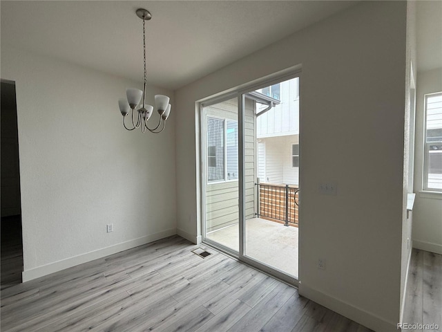 6113 Zebulon Pl, Timnath, CO 80547 - unfurnished dining area featuring light wood-style flooring, a chandelier, and healthy amount of natural light