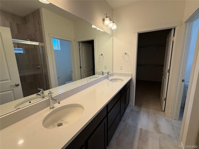 6113 Zebulon Pl, Timnath, CO 80547 - bathroom featuring toilet, double vanity, a stall shower, tile patterned floors, and a spacious closet