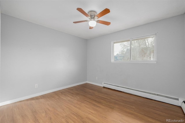 unfurnished room featuring ceiling fan, light wood-type flooring, and a baseboard heating unit