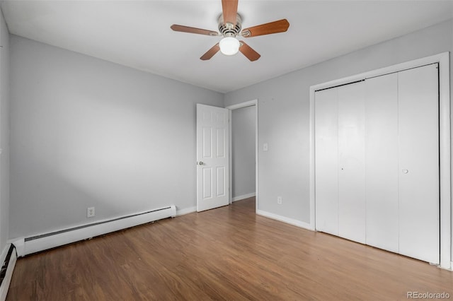 unfurnished bedroom with a closet, hardwood / wood-style floors, ceiling fan, and baseboard heating