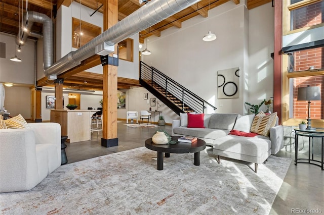 living room with a towering ceiling and concrete floors