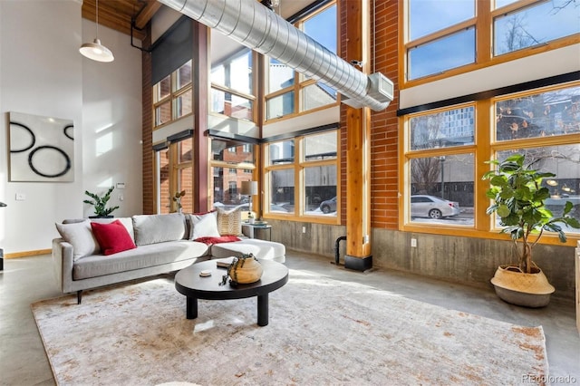 living room with a high ceiling and concrete floors