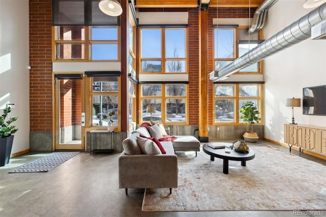 living room with a towering ceiling and concrete flooring