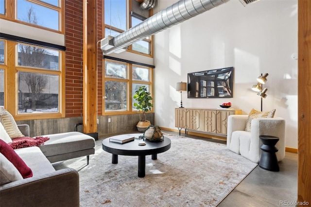 living room with a towering ceiling and concrete floors