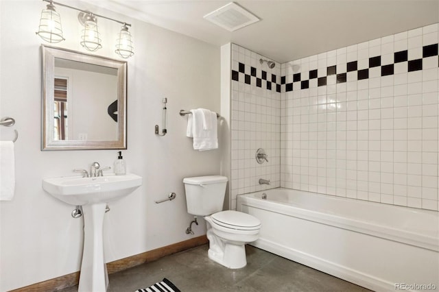 bathroom with toilet and tiled shower / bath combo