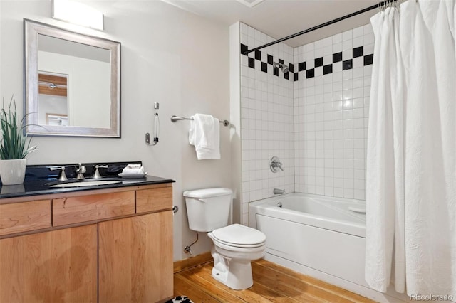 full bathroom featuring vanity, hardwood / wood-style flooring, shower / bath combination with curtain, and toilet