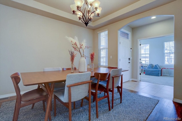 dining space featuring hardwood / wood-style floors, an inviting chandelier, and plenty of natural light