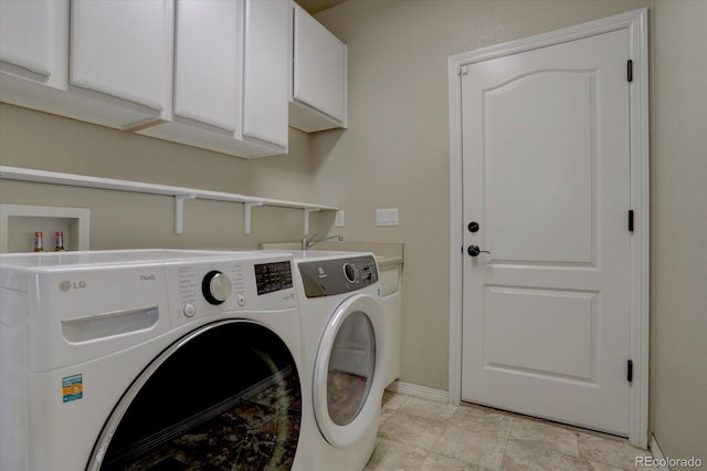 clothes washing area with cabinets and separate washer and dryer