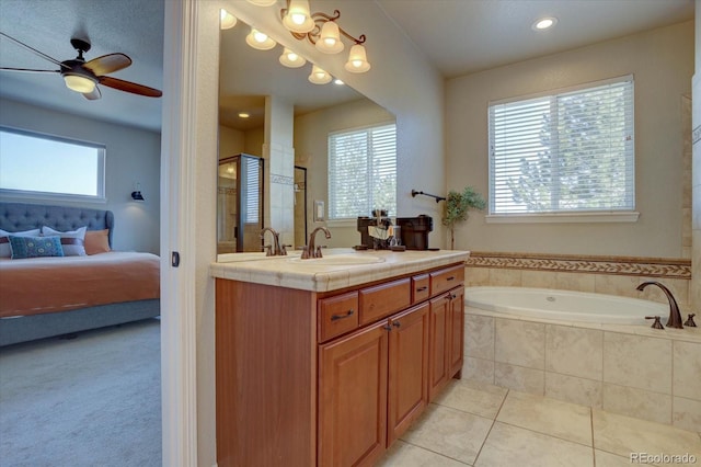 bathroom featuring tile patterned floors, tiled bath, ceiling fan, and vanity