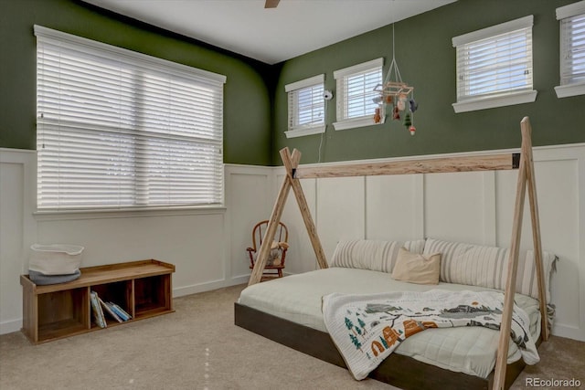 carpeted bedroom featuring multiple windows and ceiling fan