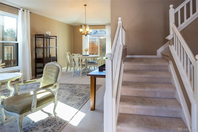 stairway featuring a chandelier