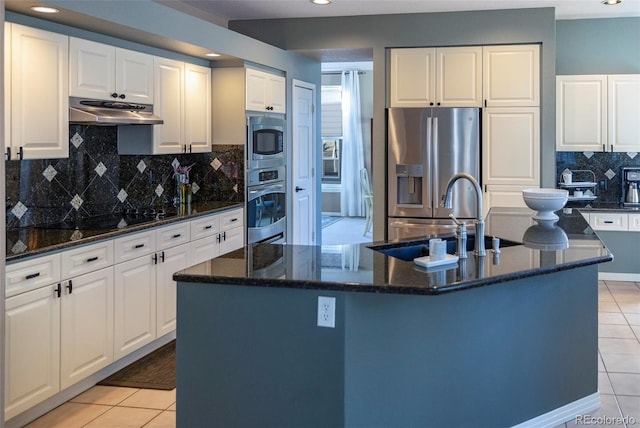 kitchen featuring stainless steel appliances, sink, a kitchen island with sink, and white cabinets