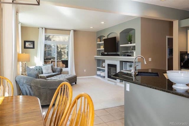 living room with sink, light tile patterned floors, and built in features