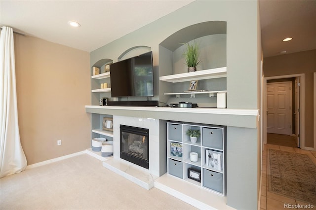 bar with light carpet, built in shelves, and a premium fireplace