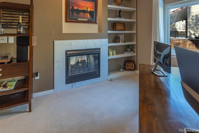 home office featuring a tile fireplace, carpet flooring, and built in features