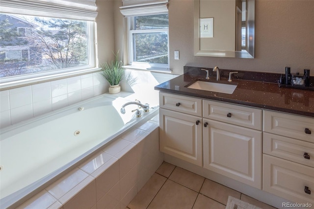 bathroom featuring vanity, a relaxing tiled tub, and tile patterned floors