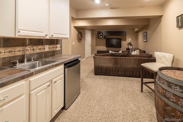 kitchen with white cabinetry, dishwasher, sink, and backsplash