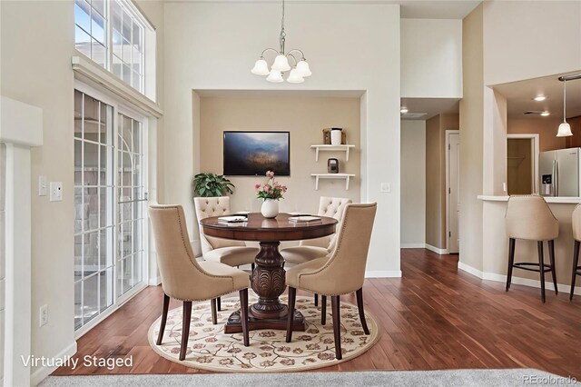 5600 W 3rd St Unit S, Greeley, CO 80634 - dining space featuring a chandelier, wood finished floors, and a towering ceiling