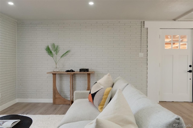 living area featuring recessed lighting, light wood-style flooring, and brick wall