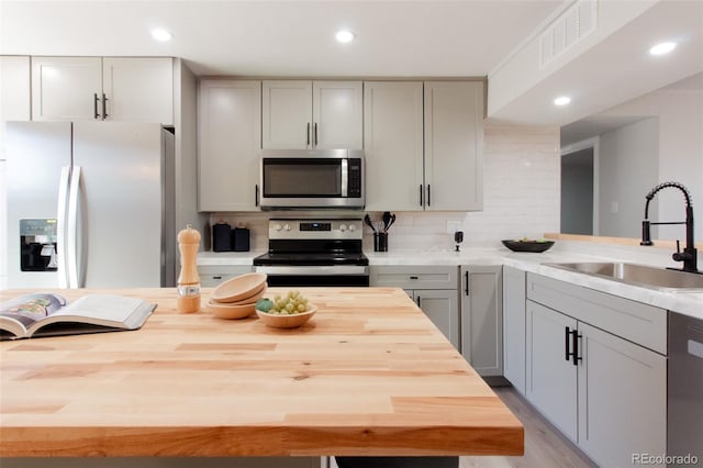 kitchen with visible vents, appliances with stainless steel finishes, butcher block counters, and a sink