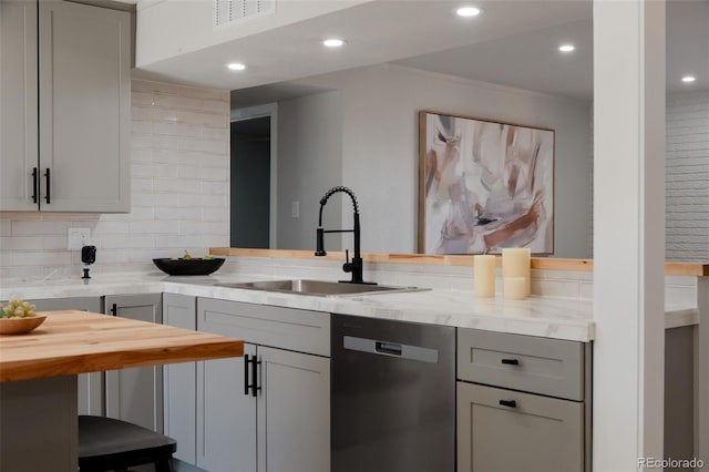 kitchen with tasteful backsplash, visible vents, gray cabinetry, stainless steel dishwasher, and a sink