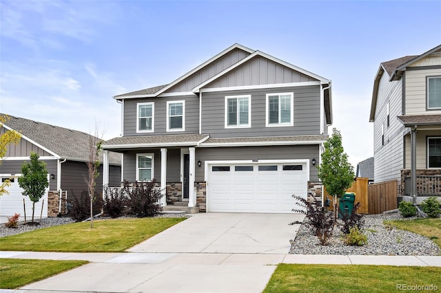 craftsman-style house featuring a front yard, a garage, and covered porch