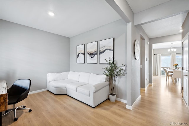 living room with an inviting chandelier and light hardwood / wood-style flooring