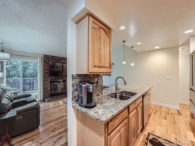 4063 S Cathay Ct, Aurora, CO 80013 - kitchen featuring open floor plan, dishwasher, light stone countertops, light wood-style floors, and a fireplace