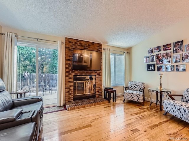 4063 S Cathay Ct, Aurora, CO 80013 - living area featuring a textured ceiling, wood finished floors, and a fireplace