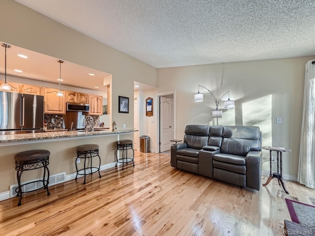 4063 S Cathay Ct, Aurora, CO 80013 - living room with light wood-style floors and a textured ceiling