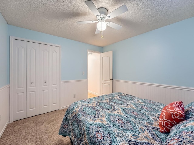 4063 S Cathay Ct, Aurora, CO 80013 - carpeted bedroom featuring wainscoting, a textured ceiling, a closet, a ceiling fan, and wooden walls