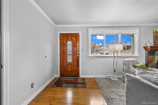 foyer with hardwood / wood-style floors, crown molding, and baseboards