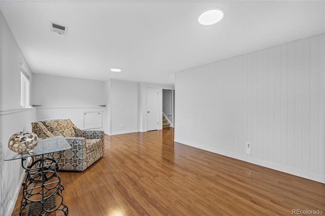 sitting room featuring stairway, wood finished floors, and visible vents