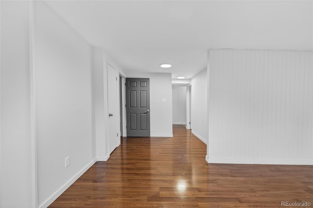 spare room featuring baseboards and wood finished floors