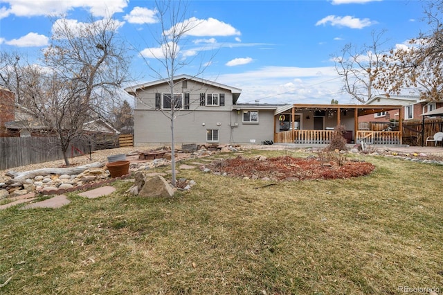 back of property featuring a lawn, covered porch, and fence