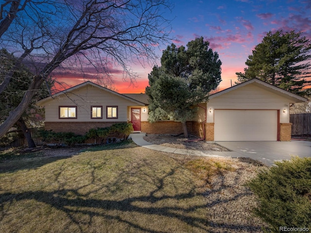 single story home featuring driveway, fence, a yard, an attached garage, and brick siding