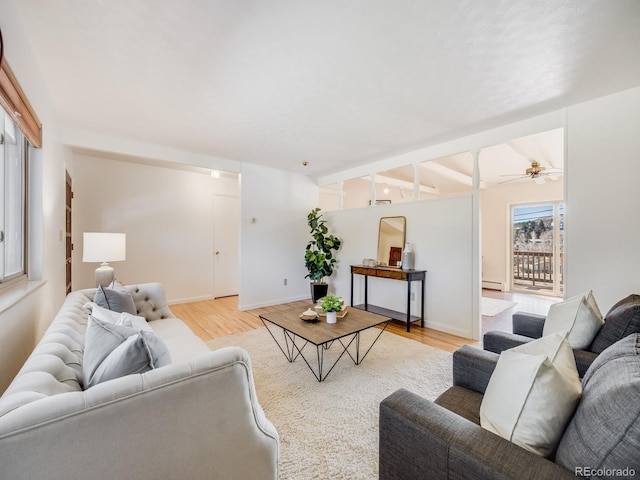 living room featuring ceiling fan, baseboards, a baseboard heating unit, and light wood-style floors