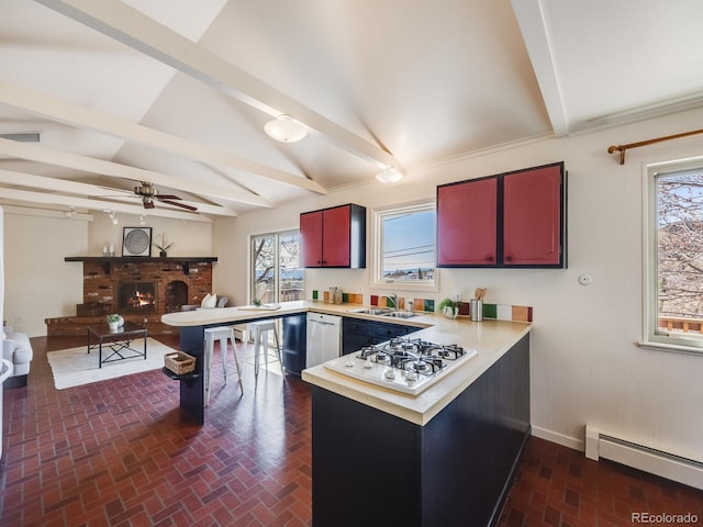 kitchen with a baseboard heating unit, white appliances, a peninsula, light countertops, and brick floor