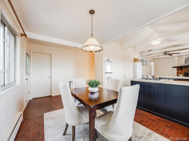 dining room with a baseboard heating unit, beamed ceiling, brick floor, and ceiling fan